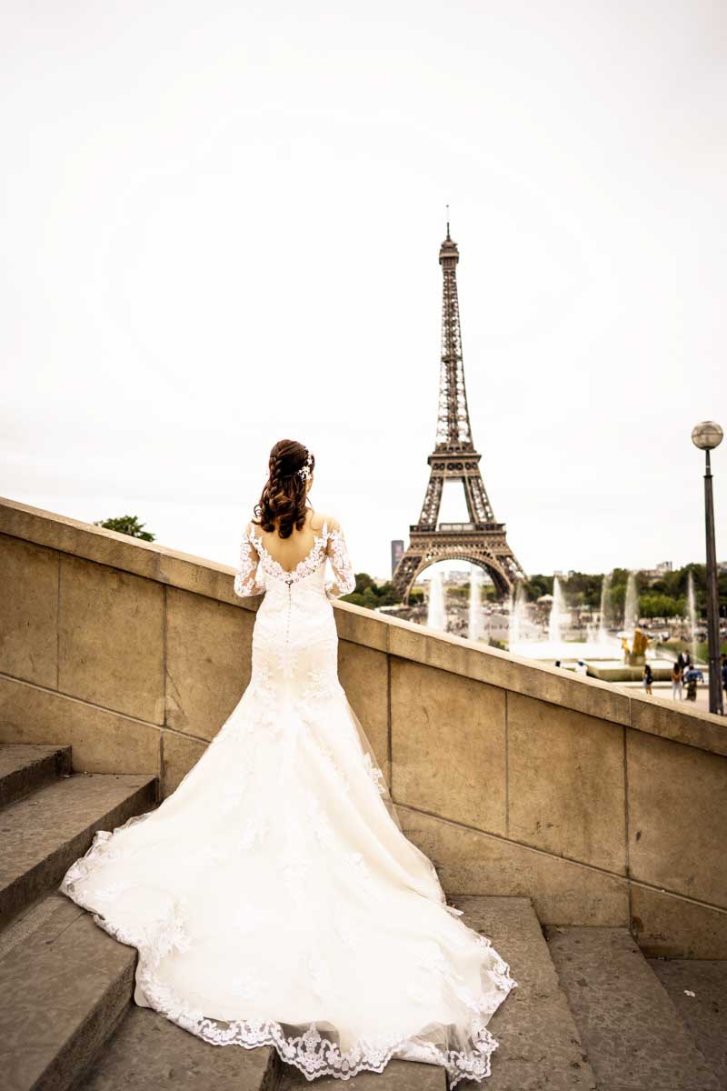 Mariée en robe regardant vers la tour Eiffel