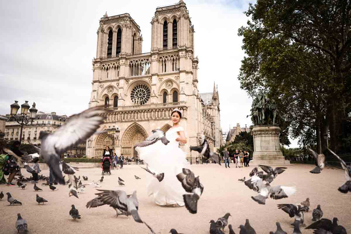 Mariée entourée de pigeons en vol près de Notre-Dame à Paris